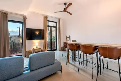 a living room with a table and chairs and a couch at La Guarida Suites in Barcelona