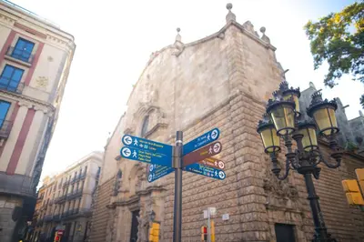 a street sign on a pole in front of a building at La Guarida Suites in Barcelona