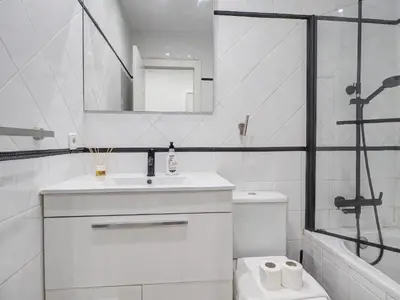 a white bathroom with a sink and a shower at White Center Apartment by Hello Homes Sitges in Sitges