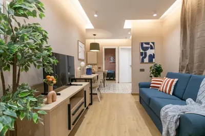 a living room with a blue couch and a tv at Sagrada Familia Xamfrà in Barcelona