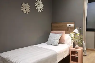 a small bedroom with a bed and a night stand at Sagrada Familia Xamfrà in Barcelona