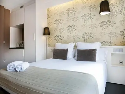 a bedroom with a large white bed with pillows at Barcelona Fifteen central Aparthotel in Barcelona