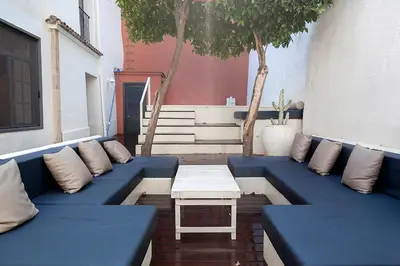 a blue couch and a table on a patio at A historic XVI century beach home near Barcelona in Caldes d'Estrac