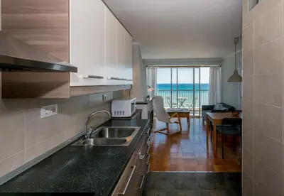a kitchen with a sink and a view of the ocean at HomeHolidaysRentals Etoile in Calella