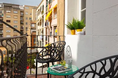 a table and chairs on a balcony with a window at Casa Cosi - Francoli 1 in Barcelona