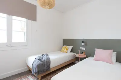 a bedroom with two beds and a window at Casa Cosi - Francoli 1 in Barcelona