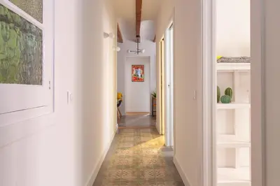 a hallway with white walls and an orange tile floor at Casa Cosi - Francoli 1 in Barcelona