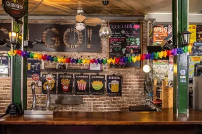 a bar with a brick wall with signs on it at Urbany Hostel BCN GO! in Barcelona