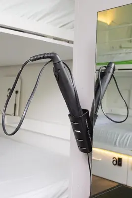a black hair dryer hanging on a wall at Urbany Hostel BCN GO! in Barcelona
