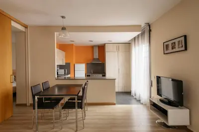 a dining room and kitchen with a table and chairs at Barcelona Apartment Villarroel in Barcelona