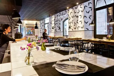 a woman standing at a table in a restaurant at Aparthotel Arai 4* Superior in Barcelona