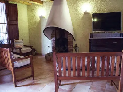 a living room with a fireplace with a bench and a tv at Mansion in Maians with Private Pool in Castellfullit del Boix