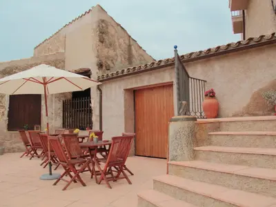 a table and chairs with an umbrella on a patio at Mansion in Maians with Private Pool in Castellfullit del Boix