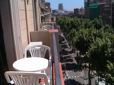 a row of white tables and chairs on a balcony at Hotel Toledano Ramblas in Barcelona