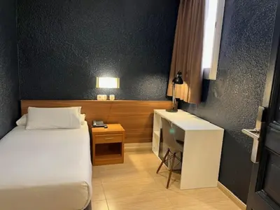 a bathroom with a white sink and a white table at Hostal Iznájar Barcelona in Barcelona