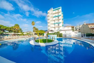 a large swimming pool in front of a building at Bamblue Boutique Apartments in Pineda de Mar
