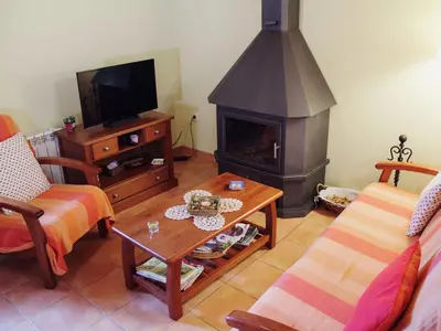 a living room with a fireplace and a table at Cottage in Maians with Sea View & Pool in Castellfullit del Boix