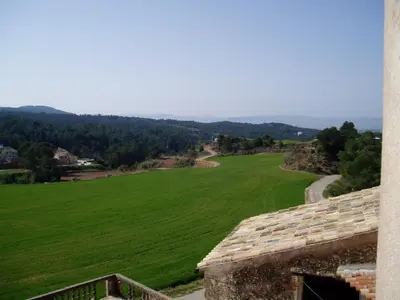 a view of a green field from a building at 17th century farmhouse in Bages, near Montserrat in Castellfullit del Boix