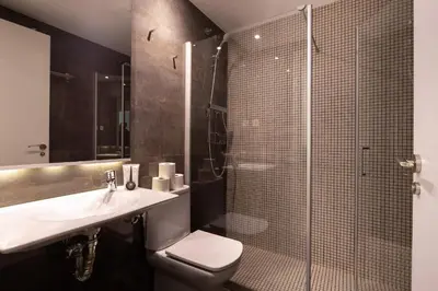 a bathroom with a toilet and a sink and a shower at Enjoybcn Patio de Gala in Barcelona