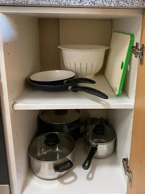 a cabinet filled with pots and pans and a bowl at Urban Manresa-City center apartment with balcony in Manresa