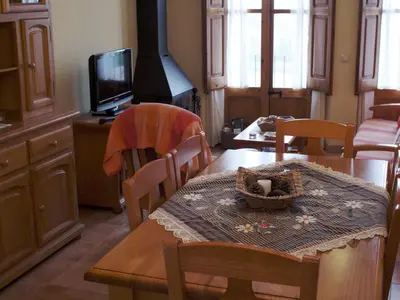 a dining room with a table and a television at Cottage in Maians with Pool and Garden in Castellfullit del Boix