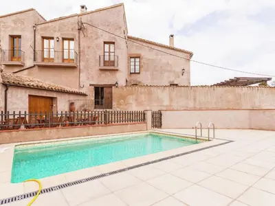 a villa with a swimming pool in front of a house at Cottage in Maians with Pool and Garden in Castellfullit del Boix