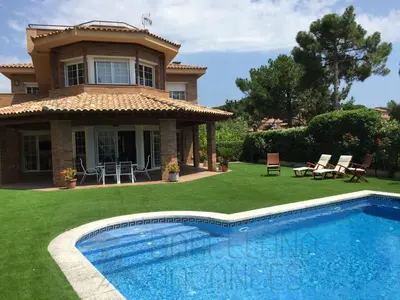 a house with a swimming pool in front of a house at BarcelonaVacances-Villa Lucia in San Pol de Mar