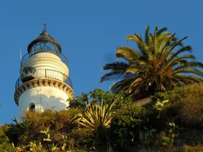 a lighthouse on top of a hill with a palm tree at UN ESPACIO DONDE CREAR GRANDES RECUERDOS in Calella