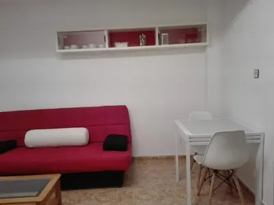 a living room with a red couch and a table at UN ESPACIO DONDE CREAR GRANDES RECUERDOS in Calella
