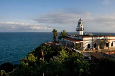 a lighthouse sitting on top of a hill next to the ocean at UN ESPACIO DONDE CREAR GRANDES RECUERDOS in Calella