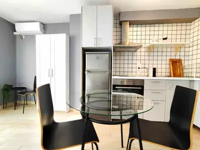 a kitchen with a glass table and black chairs at Mazi Apartments Suite in Mataró