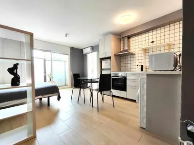 a kitchen and living room with a table and chairs at Mazi Apartments Suite in Mataró