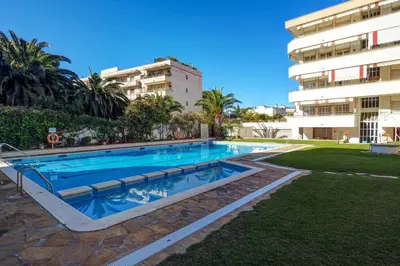 a swimming pool in front of a building at Clarimar Apartment by Hello Homes Sitges in Sitges