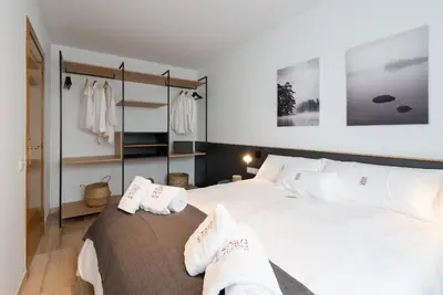 a bedroom with a large white bed with white pillows at Petit Luxe Ègara in Terrassa
