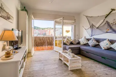 a living room with a blue couch and a tv at Vivalidays ilaria - Calella in Calella