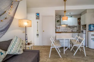 a living room with a couch and a table and a kitchen at Vivalidays ilaria - Calella in Calella