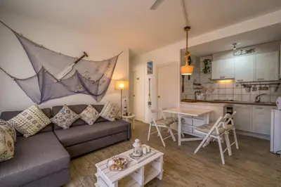 a living room with a couch and a kitchen at Vivalidays ilaria - Calella in Calella