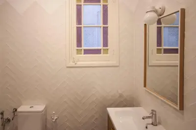 a bathroom with a toilet and a sink and a window at EG42B - Piso modernista 6 pax con WIFI en centro Barcelona in Barcelona