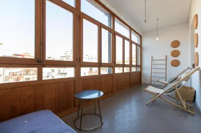 a room with a bed and a chair and windows at EG42B - Piso modernista 6 pax con WIFI en centro Barcelona in Barcelona