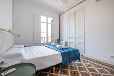 a white room with a bed with towels on it at b32-Sunny and Modernist apartment for groups in center in Barcelona