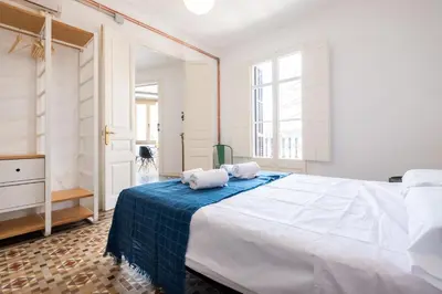 a bedroom with a large bed with two towels on it at b32-Sunny and Modernist apartment for groups in center in Barcelona