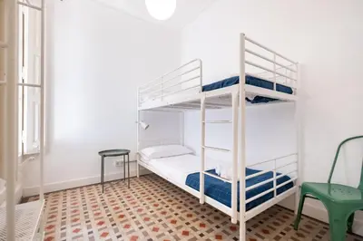 a room with two bunk beds and a green chair at b32-Sunny and Modernist apartment for groups in center in Barcelona