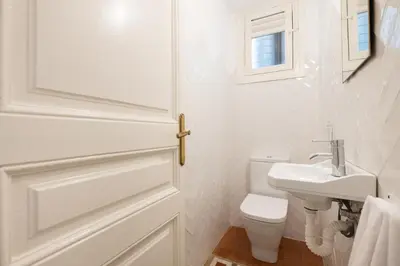 a white bathroom with a toilet and a sink at b32-Sunny and Modernist apartment for groups in center in Barcelona