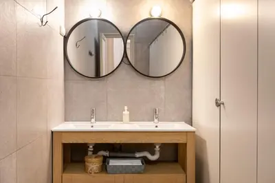 a bathroom with a sink and two mirrors on the wall at b21-Apartamento Modernista para Grupos in Barcelona
