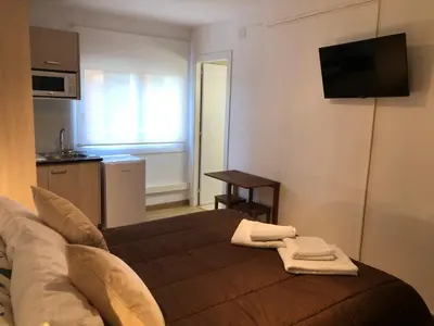 a living room with a couch and a kitchen at Hostel Penedes in Vilafranca del Penedès