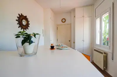 a white room with a white bed with a plant on it at Secret Garden Apartment by Hello Homes Sitges in Sitges