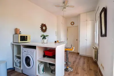 a kitchen with a washing machine and a microwave at Secret Garden Apartment by Hello Homes Sitges in Sitges