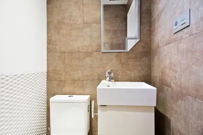 a bathroom with a toilet and a sink and a mirror at Stay U-nique Apartments Eixample Center in Barcelona