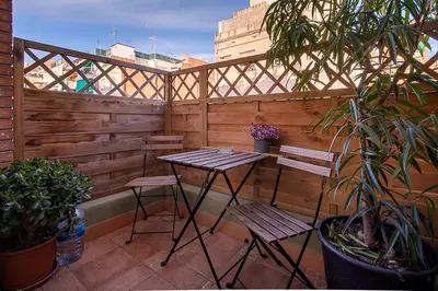 a patio with two chairs and a table and a fence at Kamelly in Badalona