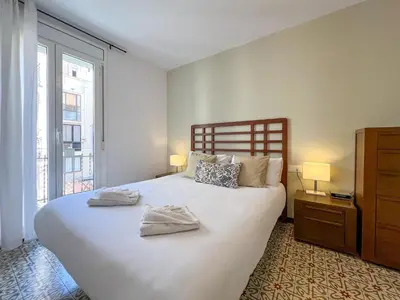 a bedroom with a large white bed with two towels on it at Stay U-nique Apartments Begur in Barcelona